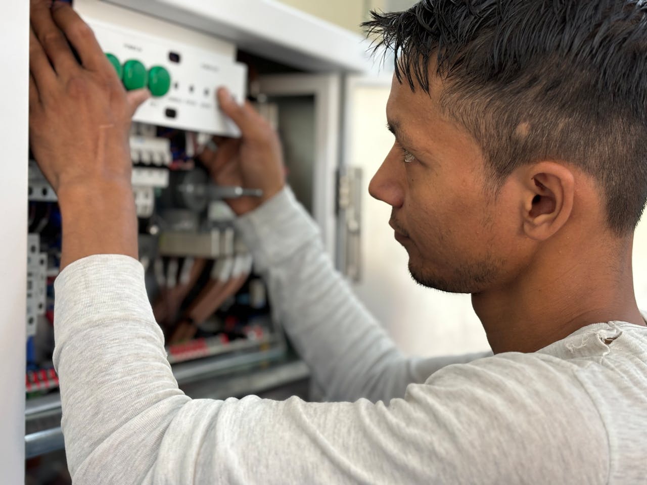 Focused electrician adjusting circuit breaker panel. Technology and skill in action.